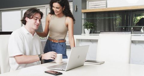 Joyful Couple Enjoying Morning Coffee While Working at Home