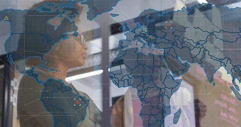 Women discussing global strategy with world map overlay and sticky notes in office