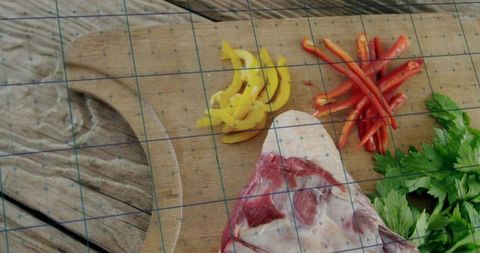 Fresh raw meat with colorful vegetables on rustic cutting board
