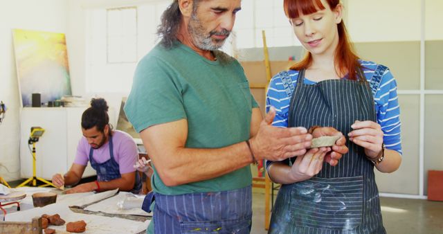 Mentor Showing Young Woman Clay Sculpting Techniques in Art Studio - Download Free Stock Images Pikwizard.com