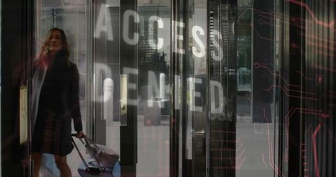 Business traveler walking through secure lobby pulling suitcase with access denied overlay