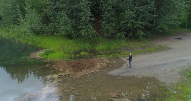 Drone View of Lone Fisherman at Peaceful Lakeshore - Download Free Stock Images Pikwizard.com