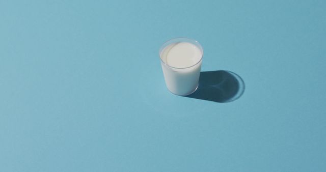 Image of glass of fresh milk over blue background. dairy products and healthy organic nutrition.
