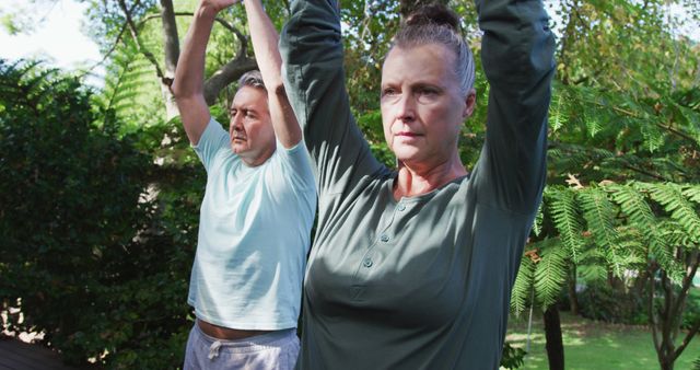 Relaxed senior caucasian couple happy practicing yoga together sitting in garden. healthy retirement fitness lifestyle.