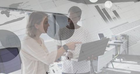 Two Businesswomen Analyzing Corporate Charts in Office Setting