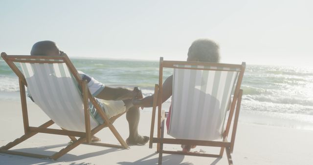Senior Couple Relaxing on Sandy Beach in Sunlight - Download Free Stock Images Pikwizard.com