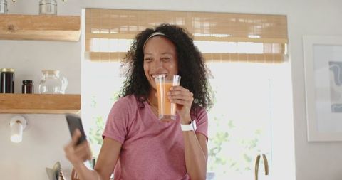 Woman Enjoying Healthy Orange Juice in Cozy Kitchen Setting