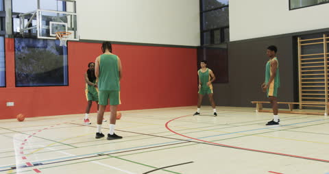 Teens Practicing Basketball Skills in Gymnasium