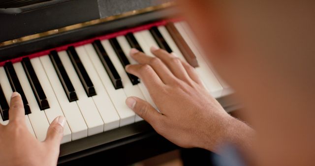 Close-up of hands playing piano, perfect for use in articles related to music education, practicing musical instruments, piano tutorials, and artistic expressions. Ideal for promoting musical performances, concerts, and therapy related to music.
