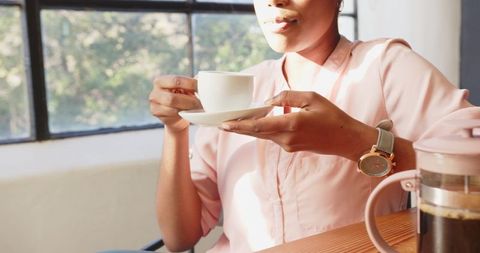 Woman enjoying coffee break in office light sunshine
