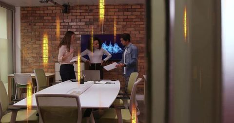 Team collaborating in modern brick conference room, finalizing business deck presentation