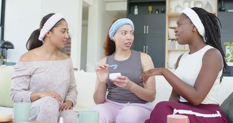 African american women sharing skincare and self-care in relaxed loungewear with friends