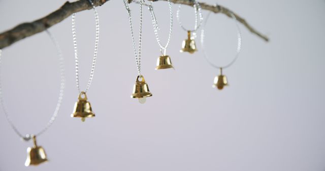 Six golden bells hanging on a branch with copy space. Decoration and domestic life, unaltered.