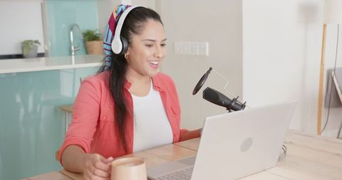 Smiling woman podcasting in modern home kitchen environment