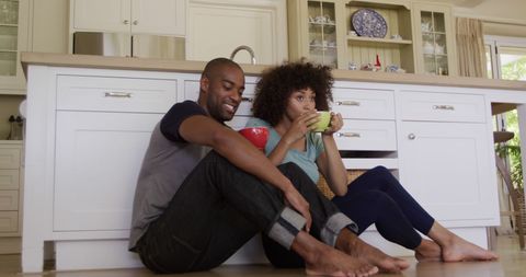 Diverse Couple Enjoying Relaxing Tea Time in Cozy Kitchen