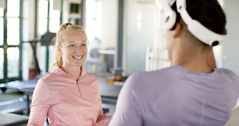 Smiling Woman Assists with Virtual Reality Therapy in Rehab Center