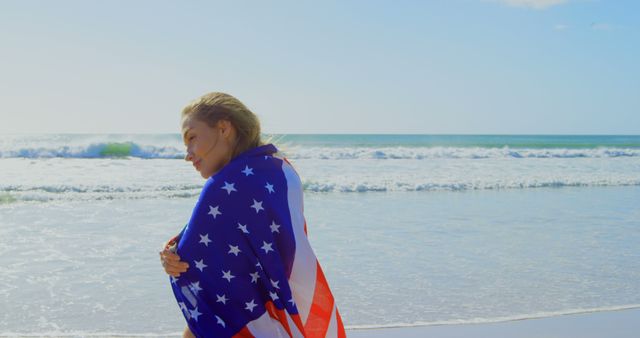 Woman Wrapped in American Flag Relaxing on Beach by Ocean - Download Free Stock Images Pikwizard.com