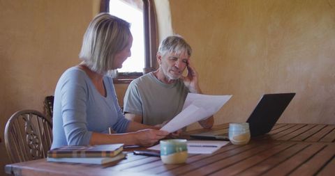 Senior Couple Reviewing Finances with Laptop and Documents
