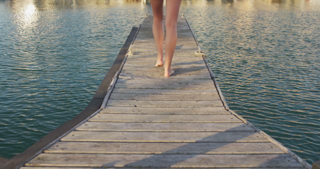 Barefoot Walking on Wooden Pier Over Water During Sunset - Download Free Stock Images Pikwizard.com