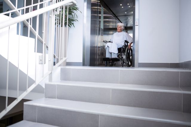 Disabled senior patient on wheelchair in lift at hospital