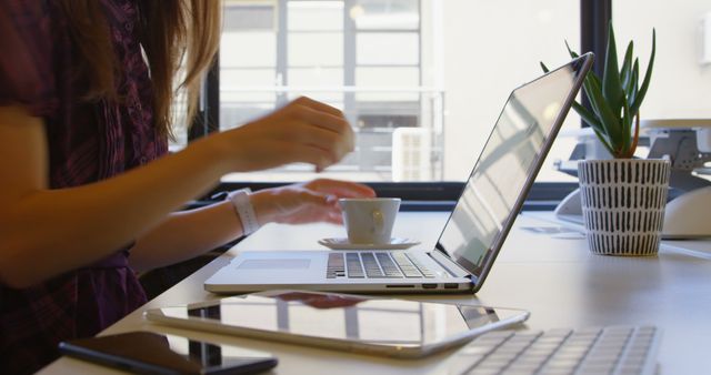 Young Businesswoman Drinking Coffee While Working on Laptop in Modern Office - Download Free Stock Images Pikwizard.com