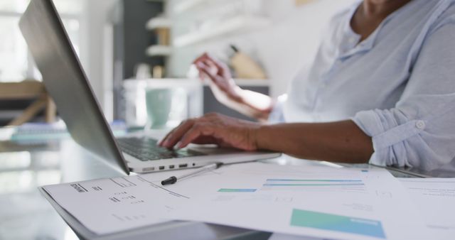 Professional Using Laptop at Desk with Financial Documents - Download Free Stock Images Pikwizard.com