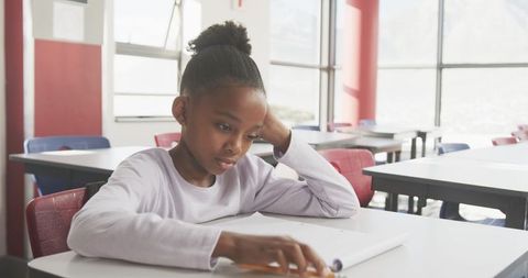 Young student concentrating on schoolwork in modern classroom