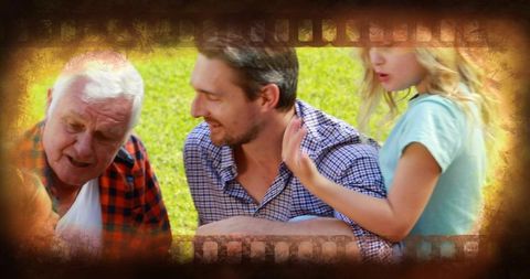 Multigenerational family sharing laughter on sunny lawn with vintage filmstrip vignette
