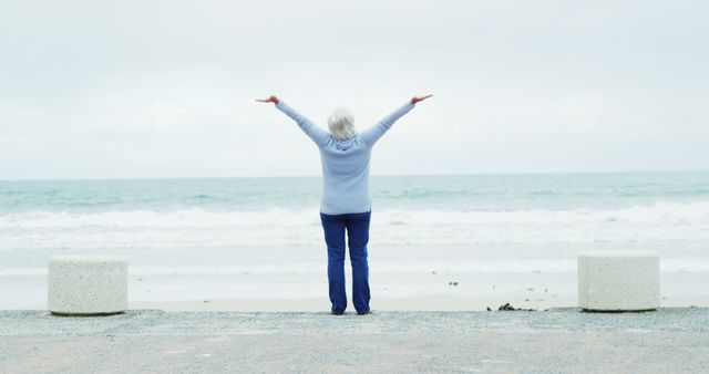 Senior Woman Enjoying Coastal View with Open Arms by the Ocean - Download Free Stock Images Pikwizard.com