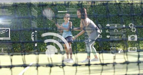 Female coach guiding young tennis player during lesson with digital sports tech overlay