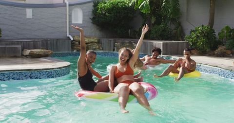 Diverse Friends Enjoying Fun at Pool Party with Inflatables