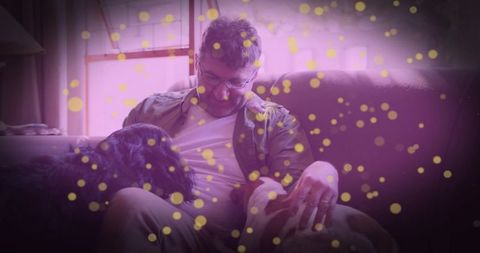 Man Relaxing with Dogs at Home Under Warm Lighting