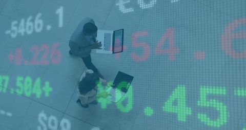 Business Professionals Analyzing Market Data with Stock Numbers Overlay