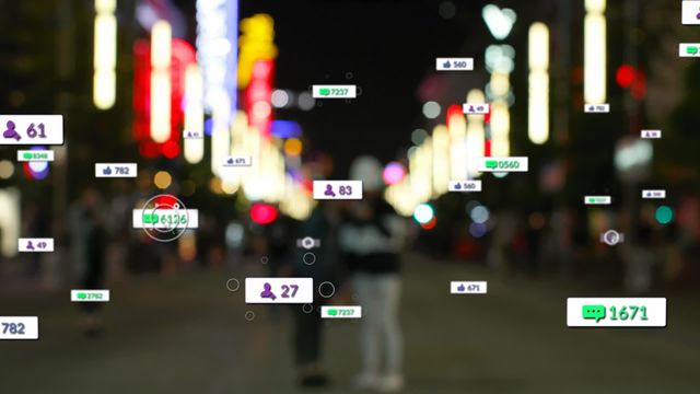 Two individuals standing on a busy city street at night with bright lights and skyscrapers out of focus in the background. Various social media analytics icons and numbers appear overlaid, illustrating concepts like connectivity, digital interactions, and online communities. Useful for depicting insights about digital marketing, the impact of social media, urban activity, and data analytics in an engaging, modern context.