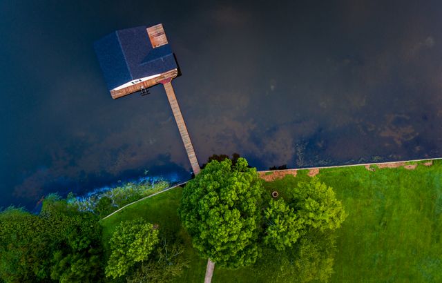 Aerial View of Lakeside Cabin and Dock Amidst Lush Greenery - Download Free Stock Images Pikwizard.com