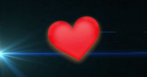 Glowing red heart with blue lens flaressymbol on dark background