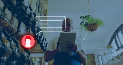 Retail owner checking tablet managing stocked shelves with digital customer chat overlay