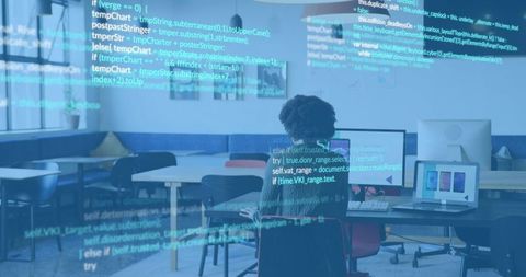 Typing woman coding at open-plan coworking desk, laptop and monitor, teal code overlay