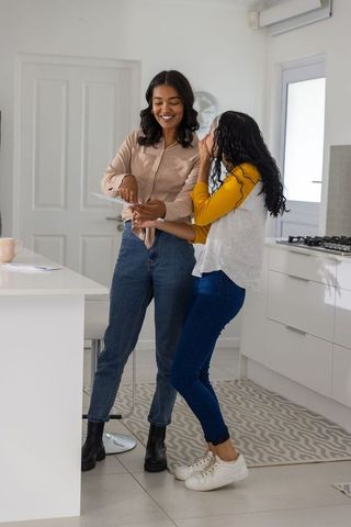 Mother and daughter discussing papers in modern kitchen