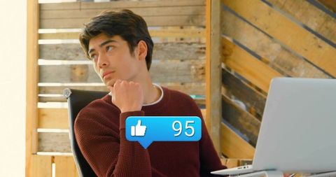 Man thinking in office with laptop and social media interaction