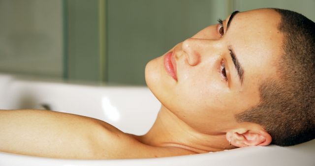 Bald woman relaxing in bathtub looking reflective - Download Free Stock Images Pikwizard.com
