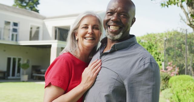 Portrait of happy senior diverse couple in garden. Spending quality time at home and retirement concept.