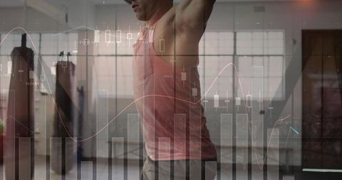 Man stretching with arms raised in industrial gym, fitness analytics charts overlay