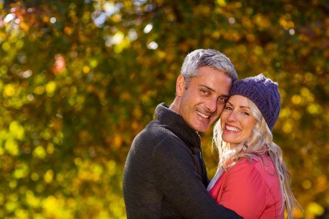Portrait of couple hugging at park during autumn