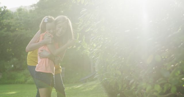 Mother and Daughter Playing in Sunlit Garden - Download Free Stock Images Pikwizard.com