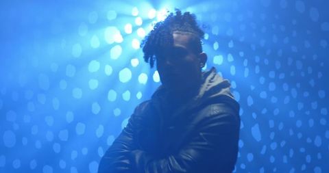 Performer Under Spotlight Creates Dramatic Silhouette with Blue Lighting
