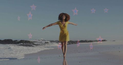 Walking woman in yellow wrap dress on sunlit beach with pastel star overlays