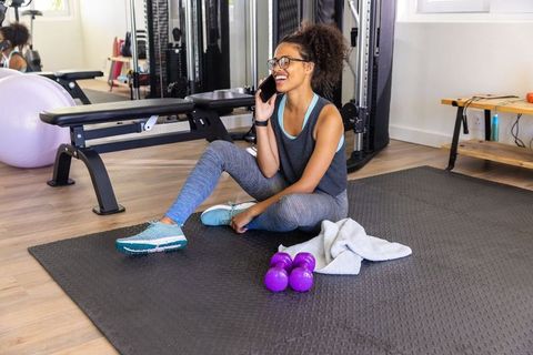 Active Woman Relaxing After Workout in Gym Setting with Fitness Equipment
