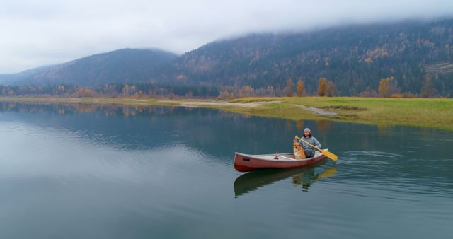 Man Canoeing on Serene Lake with His Dog in Autumn - Download Free Stock Images Pikwizard.com