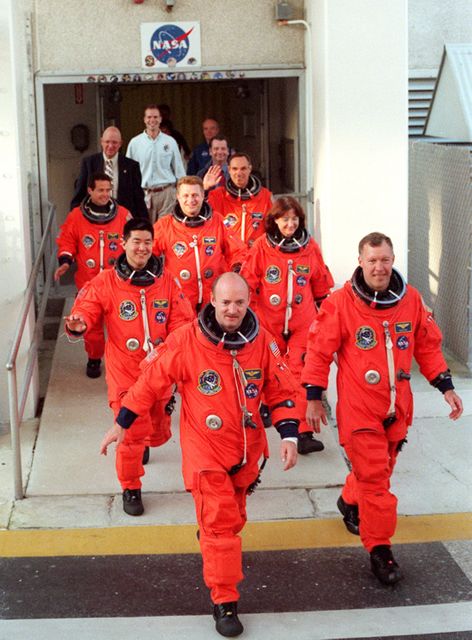KENNEDY SPACE CENTER, Fla. --  The STS-108 crew leads the way out of the Operations and Checkout Building on their way to Launch Pad 39B for a simulated launch countdown.  They are followed by the Expedition 4 crew.  From front to back, left and right, are Pilot Mark E. Kelly and Commander Dominic L. Gorie; Mission Specialists Daniel M. Tani and Linda A. Godwin; Expedition 4 Commander Yuri Onufrienko; astronauts Daniel W. Bursch and Carl E. Walz.   The simulated countdown is part of Terminal Countdown Demonstration Test activities, which have also included emergency exit training from the orbiter.  Launch of  Space Shuttle Endeavour on mission STS-108 is scheduled for Nov. 29 at 7:44 p.m. EST